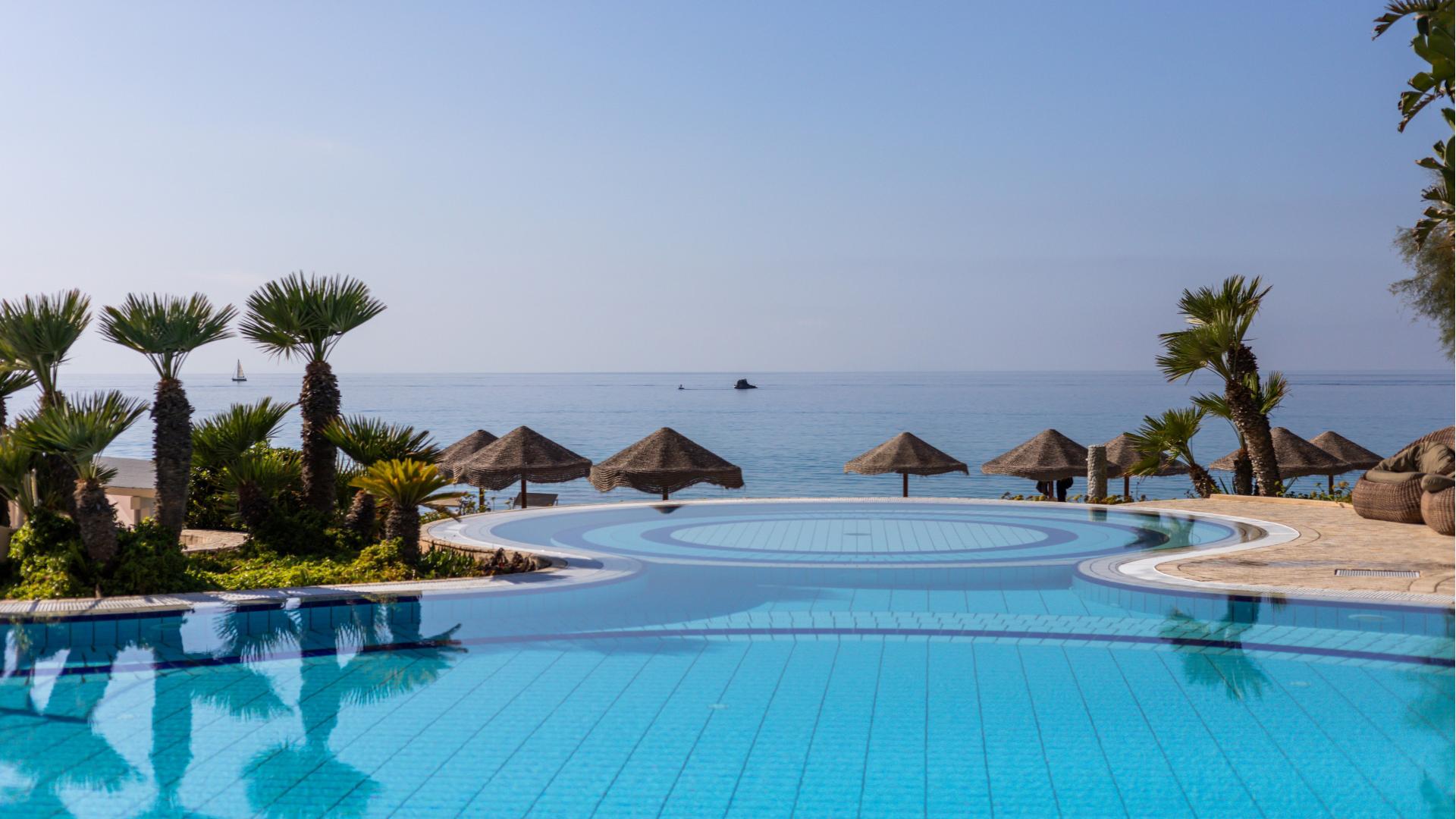 Infinity-Pool mit Meerblick und Palmen.