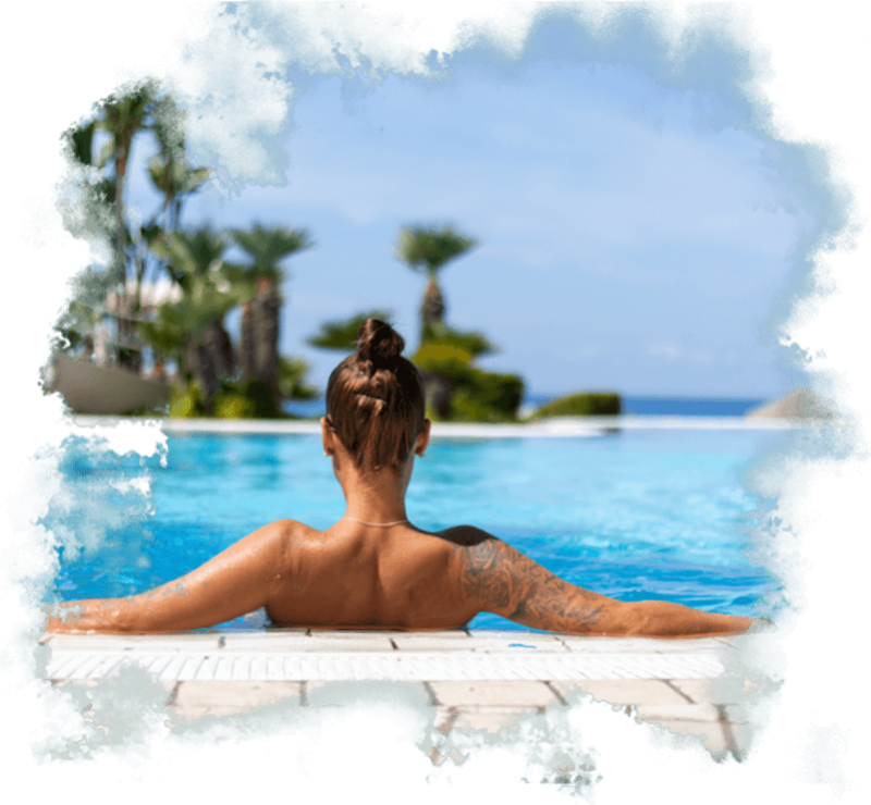 Frau entspannt im Pool mit Meerblick und Palmen.